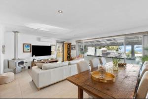 a living room with a white couch and a table at Quinns Oasis in Quinns Rocks