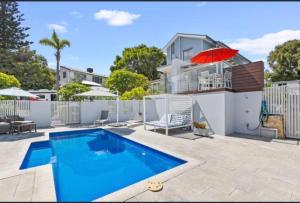 a swimming pool in front of a house at Quinns Oasis in Quinns Rocks