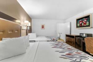 a hotel room with two beds and a flat screen tv at Red Roof Inn Houston - Jersey Village in Houston