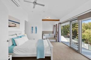 a bedroom with a white bed and a balcony at Quinns Oasis in Quinns Rocks +13 photos
