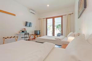 a white room with two beds and a window at Natai House Resort นาใต้เฮ้าส์ รีสอร์ท in Natai Beach