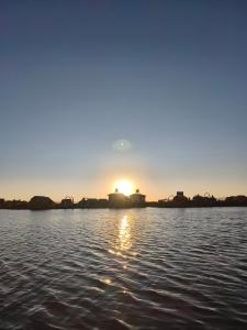 a sun setting over a body of water at Suma Kusi en el Titicaca in Puno
