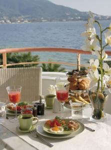 una mesa con platos de comida y copas de vino en Over Sea Rooms & Villas en Loutra Edipsou