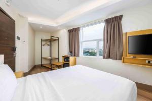 a bedroom with a large white bed and a large window at Citi Park Hotel Cebu powered by Cocotel in Cebu City