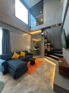 a living room with a blue couch and yellow pillows at Angela Stay in Pattaya
