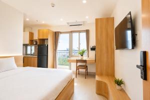 a bedroom with a bed and a kitchen with a table at Minh Khang Apartment in Danang