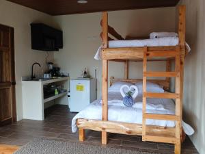 a bedroom with two bunk beds and a kitchen at Refugio de Paz Providencia in El Copey
