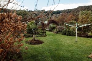a garden with a gazebo and green grass at Aurum Retreat in Reefton