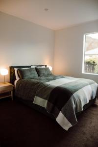 a bedroom with a large bed and a window at Aurum Retreat in Reefton
