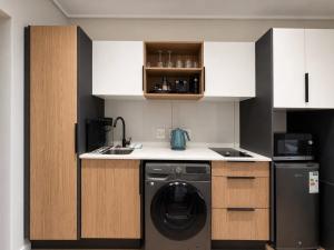 a small kitchen with a washing machine and a sink at 410 On Park in Cape Town +4 photos