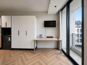 a room with a desk with a tv and a kitchen at 410 On Park in Cape Town