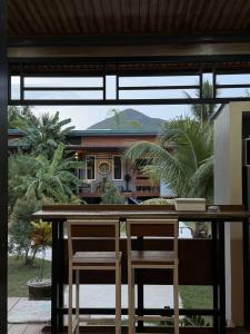 a table with two chairs in front of a house at CS phangan Villa in Ko Phangan +3 photos