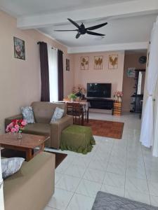 a living room with a couch and a ceiling fan at Laman D'Manees in Kampung Bukit