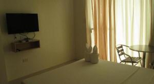 a living room with a table and a television and a table and chair at Jeffrey S Hotel in Boracay