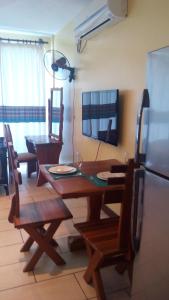 a dining room with a wooden table and chairs at Sunny Beachfront Studio in Mombasa