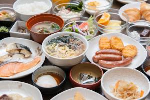 a table topped with bowls of different types of food at Dormy Inn Kagoshima in Kagoshima