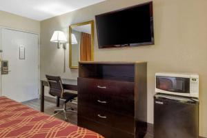 a hotel room with a bed and a television and a desk at Econo Lodge Columbia Fort Jackson in Burnside East