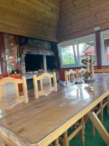 a large wooden table in a room with a fireplace at Cabana Daria in Gârda de Sus