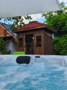 a small house with a pool in front of a building at Vár-Liget Vendégház in Kisnána