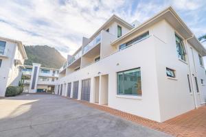 an exterior view of a white building at Capri on Pilot Bay in Mount Maunganui