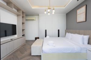 a bedroom with a large bed and a flat screen tv at Elite Suites Villas Maikhao Phuket in Mai Khao Beach +57 photos