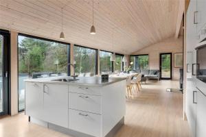 a kitchen with white cabinets and a large group of windows at 0410-Romo-Strandskaden-15 in Høm