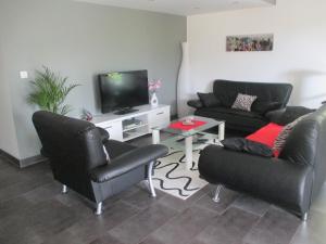 a living room with two couches and a tv at Villa Verdi in Ostheim