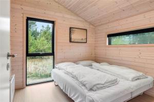 a bedroom with two beds in a room with windows at 0410-Romo-Strandskaden-15 in Høm