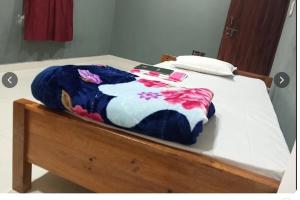 a bed with a blue and white blanket on it at Hotel Alpha in Imphal International Airport