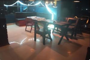 a table and chairs in a room with lights at Hotel Alpha in Imphal International Airport