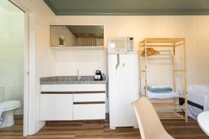 a small kitchen with a refrigerator and a sink at Marco Zero Containers - Próximo à Roda Gigante in Balneário Camboriú +96 photos
