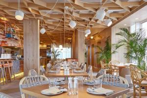 a restaurant with wooden ceilings and tables and chairs at BISHA, a Luxury Collection Hotel, Toronto in Toronto