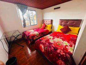 a bedroom with two beds and a window at Nuevo Hotel Transportador in Bogotá +11 photos