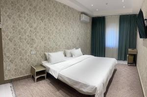 a bedroom with a large white bed in a room at Tashkent City View Apartments in Tashkent