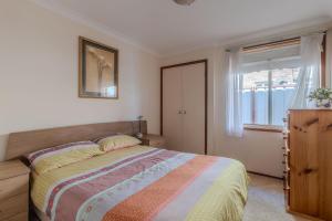 a bedroom with a bed and a window at Fishermans Delight Waterfront in Sussex Inlet