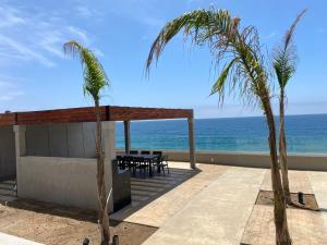 a patio with a table and palm trees on the beach at Wabi Sabi in Rosarito +3 photos