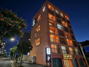 a tall building on a city street at night at Jeju Lavender Hotel in Seogwipo