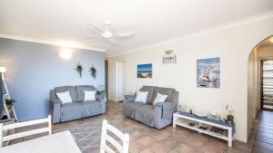 a living room with two couches and a table at Great Views, Ground Floor Unit in Bongaree +16 photos