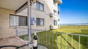 a bottle of wine on a balcony of a house at Great Views, Ground Floor Unit in Bongaree