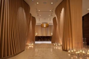 a hallway with brown curtains and a room with a table at ME by Meliá Milan Il Duca in Milan