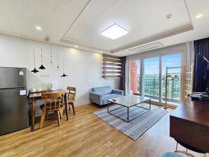a kitchen and living room with a table and a refrigerator at Jeju Lavender Hotel in Seogwipo