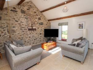 a living room with two couches and a flat screen tv at Wern Olau Cottage in Caernarfon
