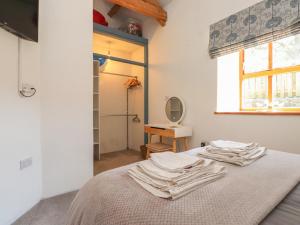 a bedroom with a bed with towels on it at Wern Olau Cottage in Caernarfon
