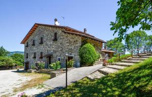 an old stone house with a staircase leading up to it at Oasi Di Cocciola in Badia Tedalda