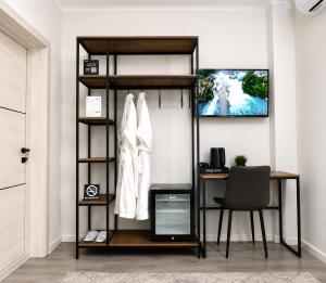 a room with a desk and a shelf with a coat at Urban Hotel in Bishkek
