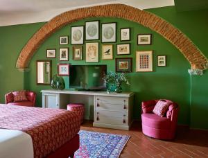 a bedroom with a green wall with a bed and two chairs at Hotel Tenuta di Artimino member of Meliá Collection in Artimino