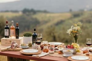 a table with food and bottles of wine on it at Hotel Tenuta di Artimino member of Meliá Collection in Artimino
