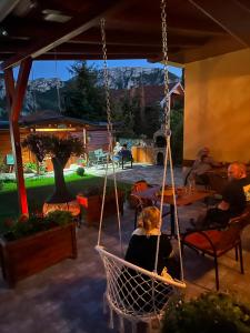 a woman sitting in a swing in a patio at Ramonda Serbica - Gorge View & Peacful Nature Retreat in Niš
