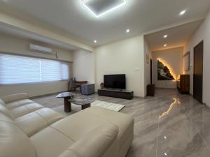 a living room with a couch and a television at Plaza Hotel in Dili