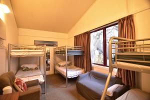a room with three bunk beds and a window at Stay In Tekapo Backpackers in Lake Tekapo